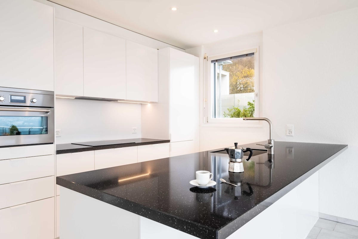 Kitchen island finished with a polished black granite countertop