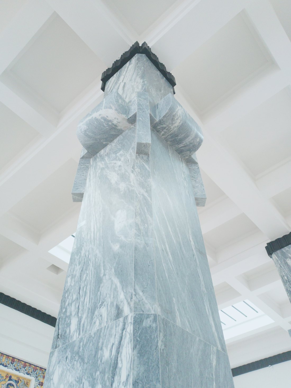 Sculptural marble column inside a modern hall